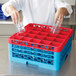 A chef using a Carlisle red glass rack with extenders to store glasses.