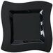 A close up of a Fineline black plastic square plate with a wavy design.