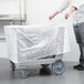 A person using a plastic cover to protect a Cambro dish caddy.