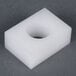 A white plastic square with a hole in it.