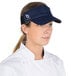 A woman wearing a navy blue Headsweats visor.