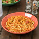 A bowl of pasta with sauce in a green Diamond Mardi Gras melamine bowl.