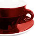 A close up of a red CAC Venice coffee cup and saucer.