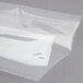 A clear plastic bag with a shadow on a white surface.