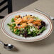 A Tuxton Bahamas brown speckle narrow rim china bowl filled with salad.