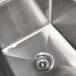 A stainless steel Advance Tabco three compartment commercial sink with two drainboards.