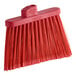 A red Carlisle broom head with flagged bristles.