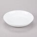 A 10 Strawberry Street white porcelain soup bowl on a gray surface.