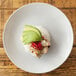 A 10 Strawberry Street white porcelain soup bowl with rice and avocado on a table.