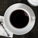 A 10 Strawberry Street white porcelain cup of coffee on a saucer.