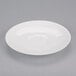 A white porcelain saucer with a round center on a gray surface.