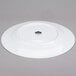 A white 10 Strawberry Street porcelain charger plate with a black rim on a gray surface.