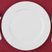 A white 10 Strawberry Street porcelain charger plate with a fork and knife