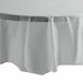 A white table with a Creative Converting Shimmering Silver plastic table cover on it.