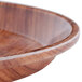 A Cambro round fiberglass tray with a Java Teak design on a table in a salad bar.