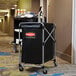 A black Rubbermaid laundry cart with a red logo.