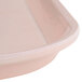 A close up of a light peach Cambro square tray.