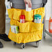 A person holding a yellow Lavex nylon bag with cleaning supplies.