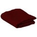 A folded burgundy rectangular table cover.