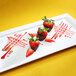 A plate of chocolate covered strawberries with a Zeroll stainless steel deco spoon with a beech wood handle.