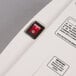 The red switch on a Grindmaster-Cecilware water pump with a black frame.