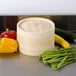 Town bamboo steamer set on a counter with baskets of vegetables and food inside.