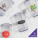 A group of clear glass pitchers with logos on them.