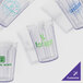 A group of clear GET plastic tumblers with customized green text.