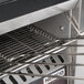 A Nemco conveyor toaster with a wire rack over the conveyor.