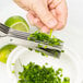 Mercer Culinary herb shears cutting green herbs.