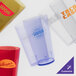 A group of red GET plastic tumblers with a pebbled texture.
