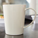 A white Carlisle Tritan mug with a handle on a table.