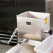 A Weston stainless steel manual meat mixer with removable paddles in a large metal container.
