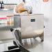 A man pouring brown liquid into a Weston Manual Meat Mixer.