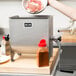 A person pouring meat into a Weston Manual Meat Mixer.