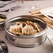 A stainless steel dim sum steamer filled with dumplings on a table.