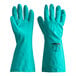 A pair of San Jamar green rubber gloves with a flock lining on a counter.