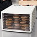 A Weston food dehydrator with trays of food inside.