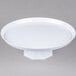 A Fineline white cake stand with a round base holding a white plate.