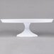 A Fineline white pedestal cake stand on a white table.