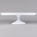 A Fineline white cake stand on a white pedestal.