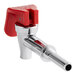 A close-up of a red and white Bunn push faucet assembly.