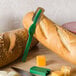 A Matfer Bourgeat bread lame with a cover on a cutting board with bread and cheese.
