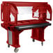 A red Cambro Versa food cart on a counter.