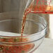 A bowl of Admiration Red Italian Style Vinegar being poured into another bowl.