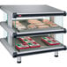 A Hatco countertop display case with double slanted glass shelves holding food.