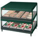 A Hunter green Hatco countertop display case with food on slanted shelves.