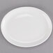 A Tuxton oval china platter with a white center and rim on a gray surface.