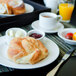 A Tuxton AlumaTux Pearl White china plate with food and a cup of coffee on a table.