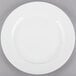 A Tuxton AlumaTux pearl white china plate with a white rim on a gray surface.